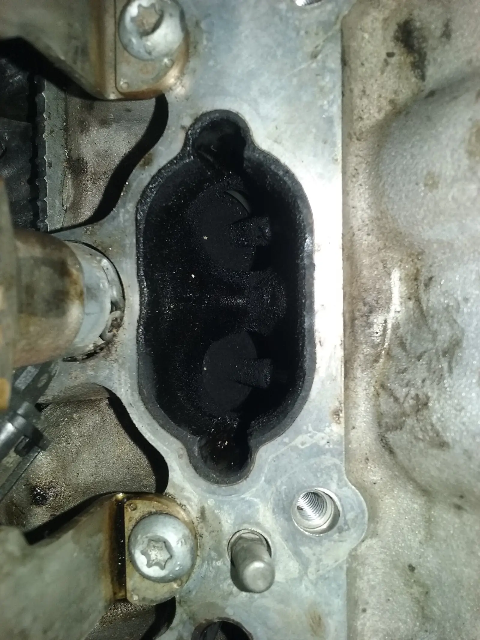 Close-up van een motorblok met een open inlaatpoort, tijdens een reparatie in de werkplaats
